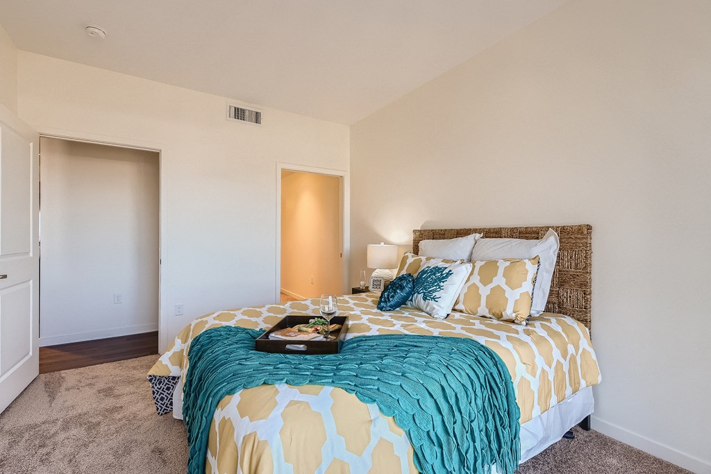a bedroom with a large bed with a colorful comforter and pillows