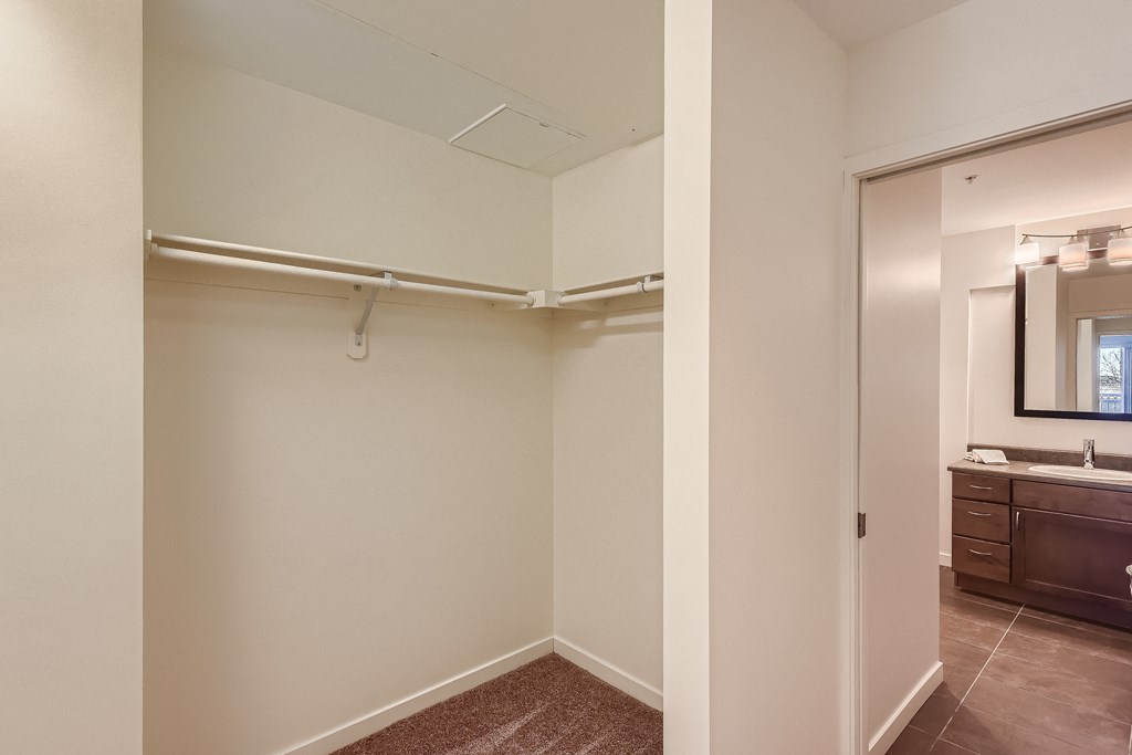 the living room of an apartment with a closet and a bathroom