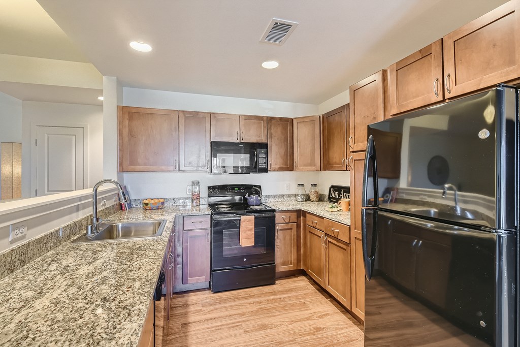 a kitchen with granite counter tops and wooden cabinets