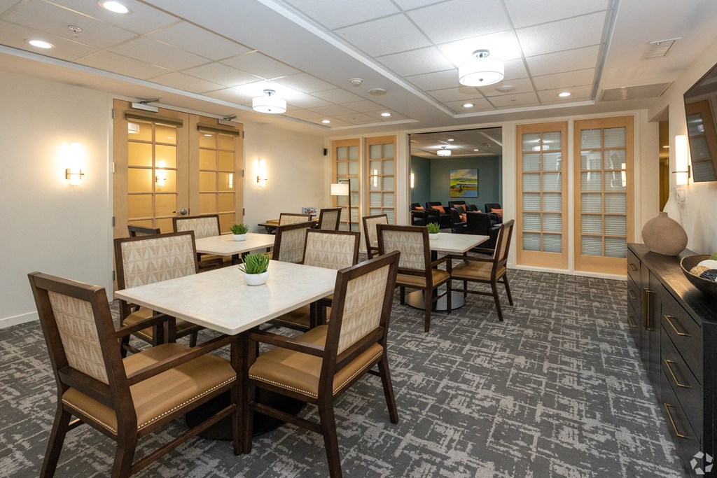 a game room with tables and chairs and a TV