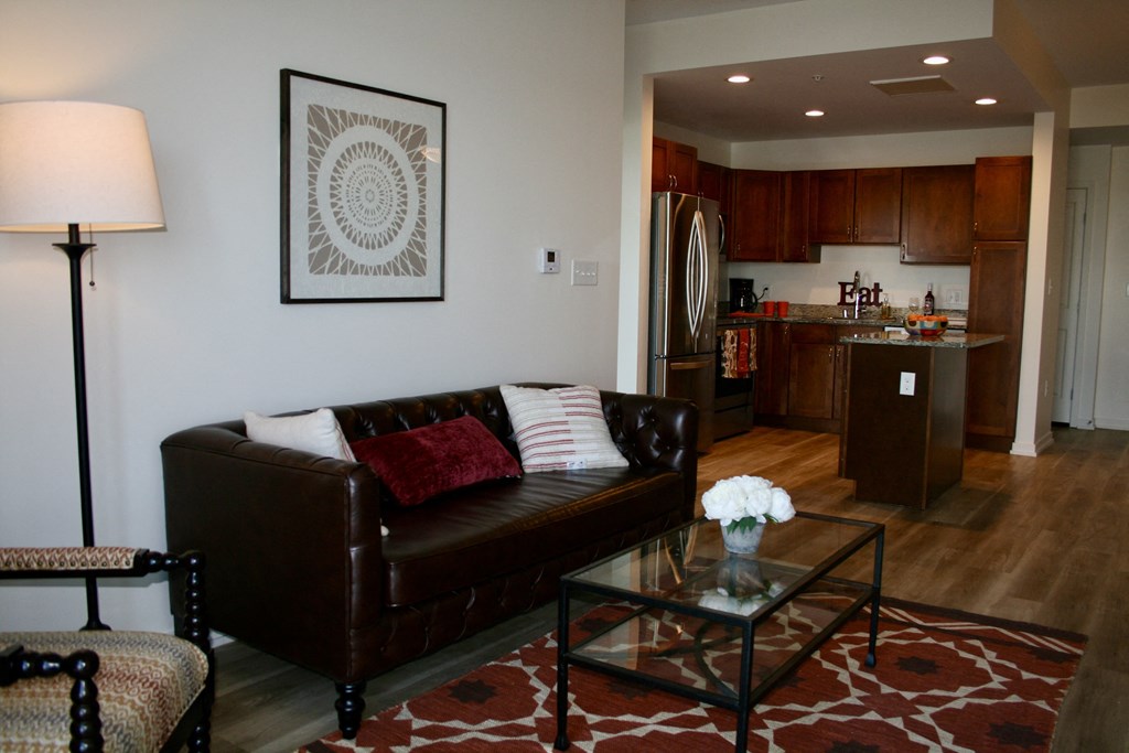 a living room with a leather couch and a glass coffee table