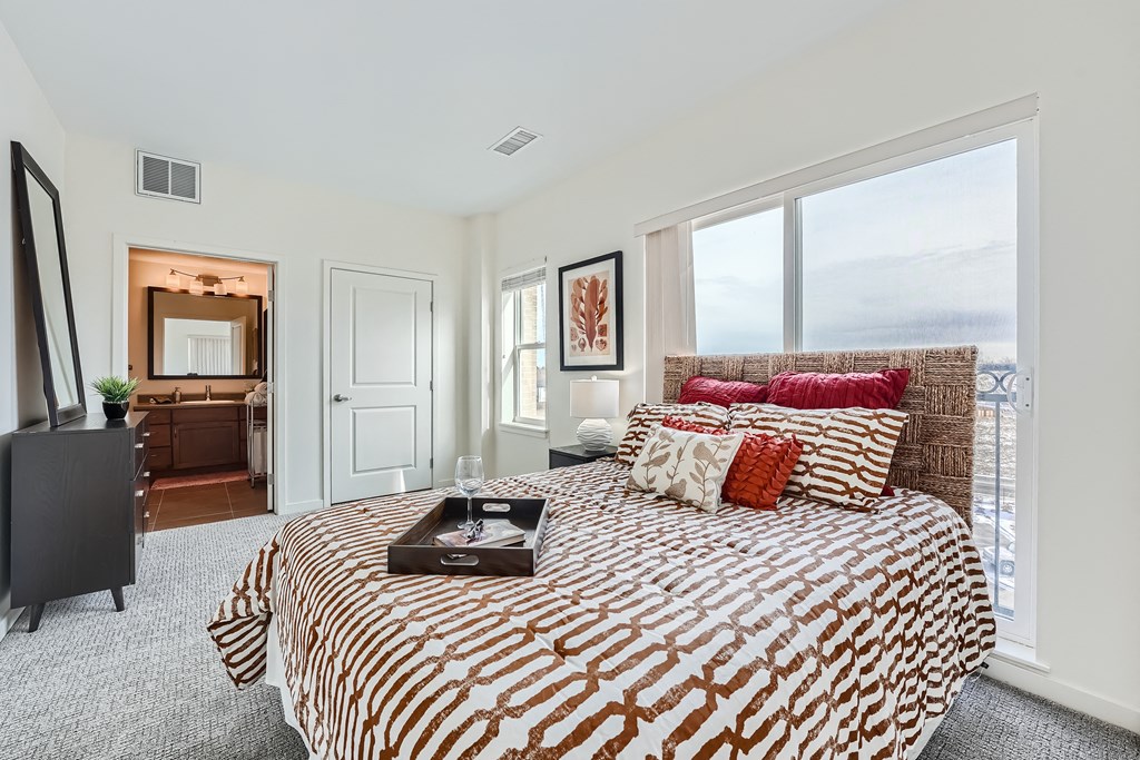 a bedroom with a bed and a large window