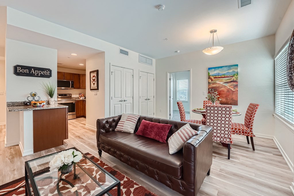 a living room with a leather couch and a table with chairs