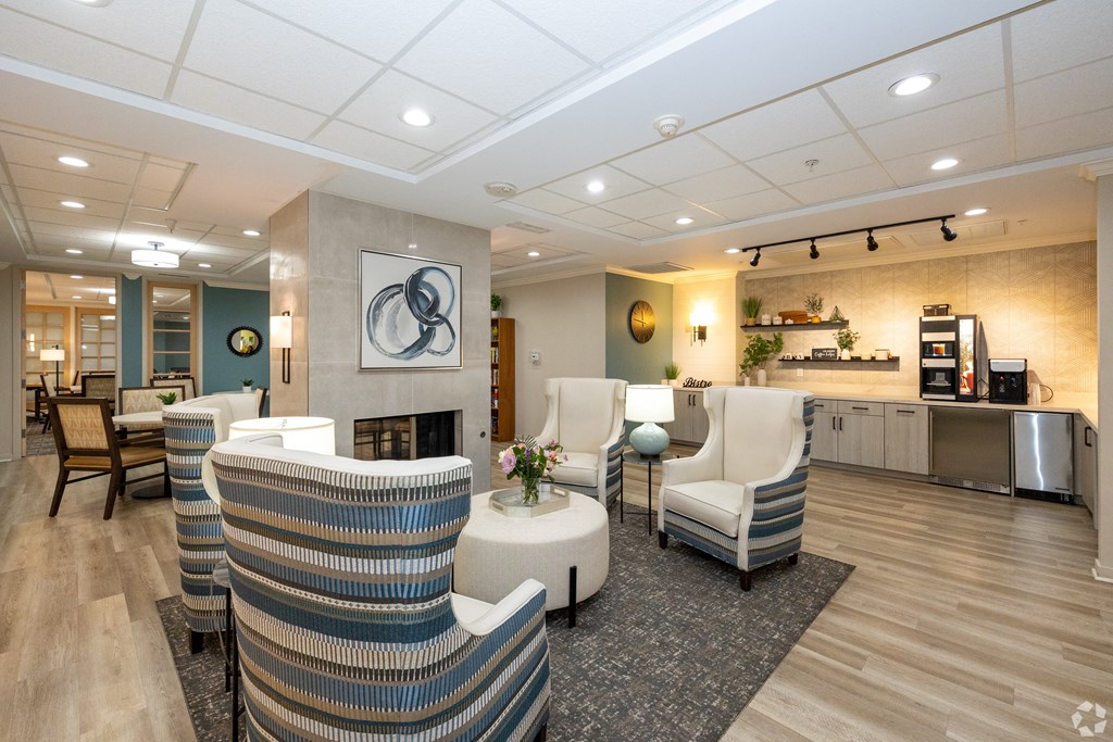 a lobby with chairs and a table and a fireplace
