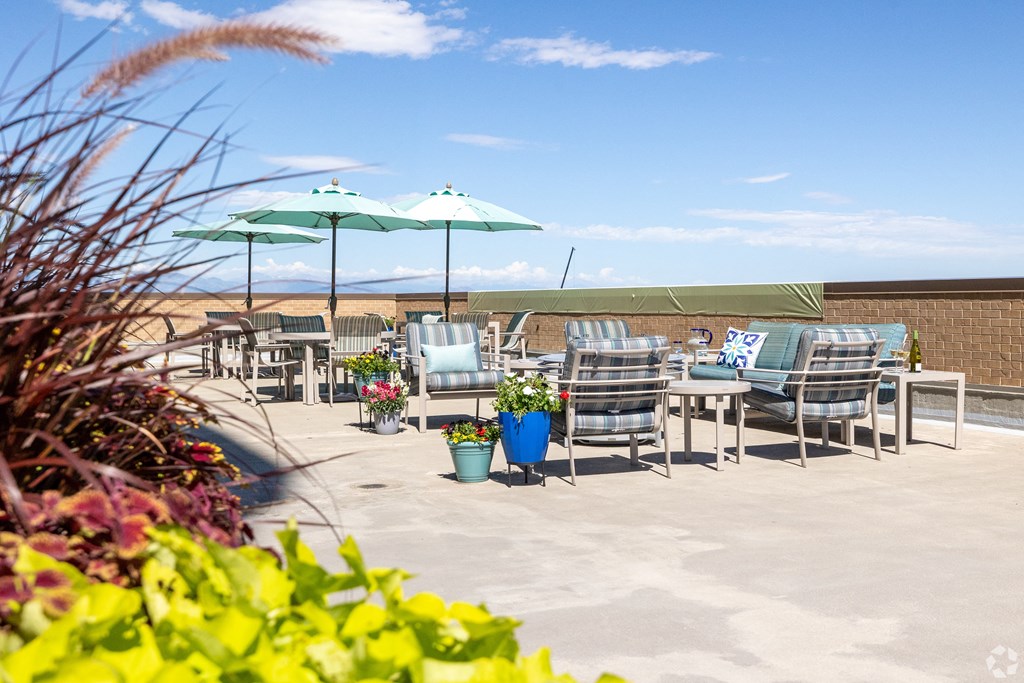 a patio with tables and chairs and umbrellas on a roof