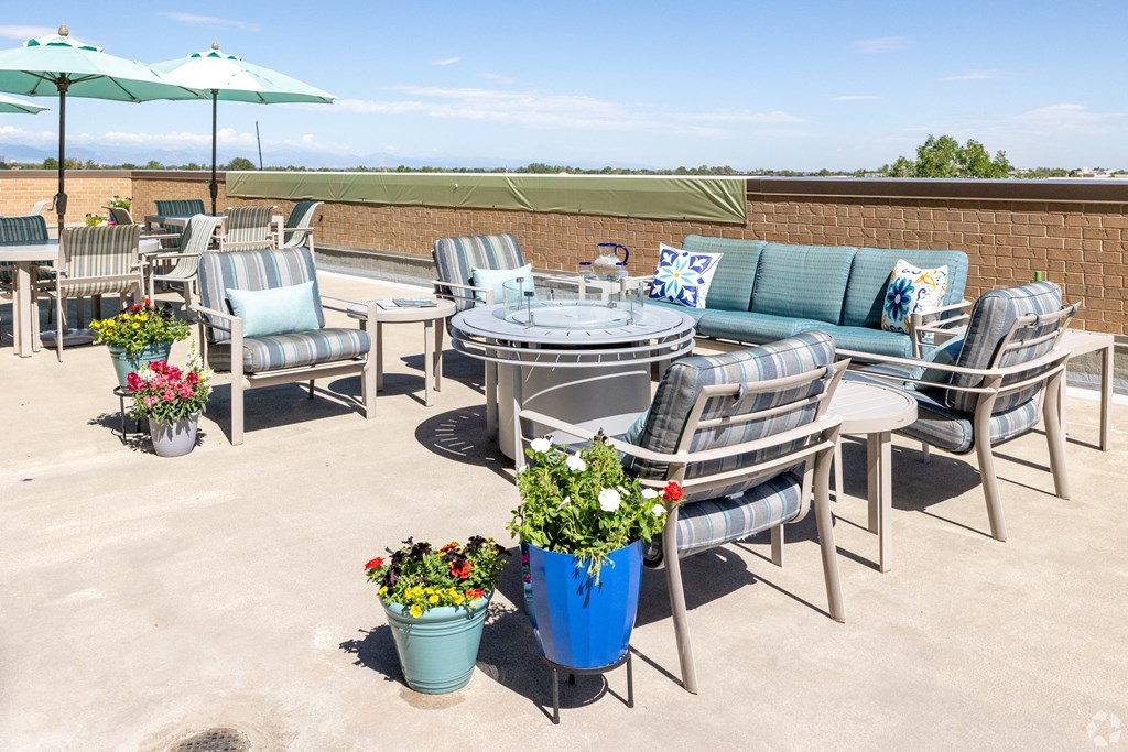 an outdoor patio with firepit seating and flowers