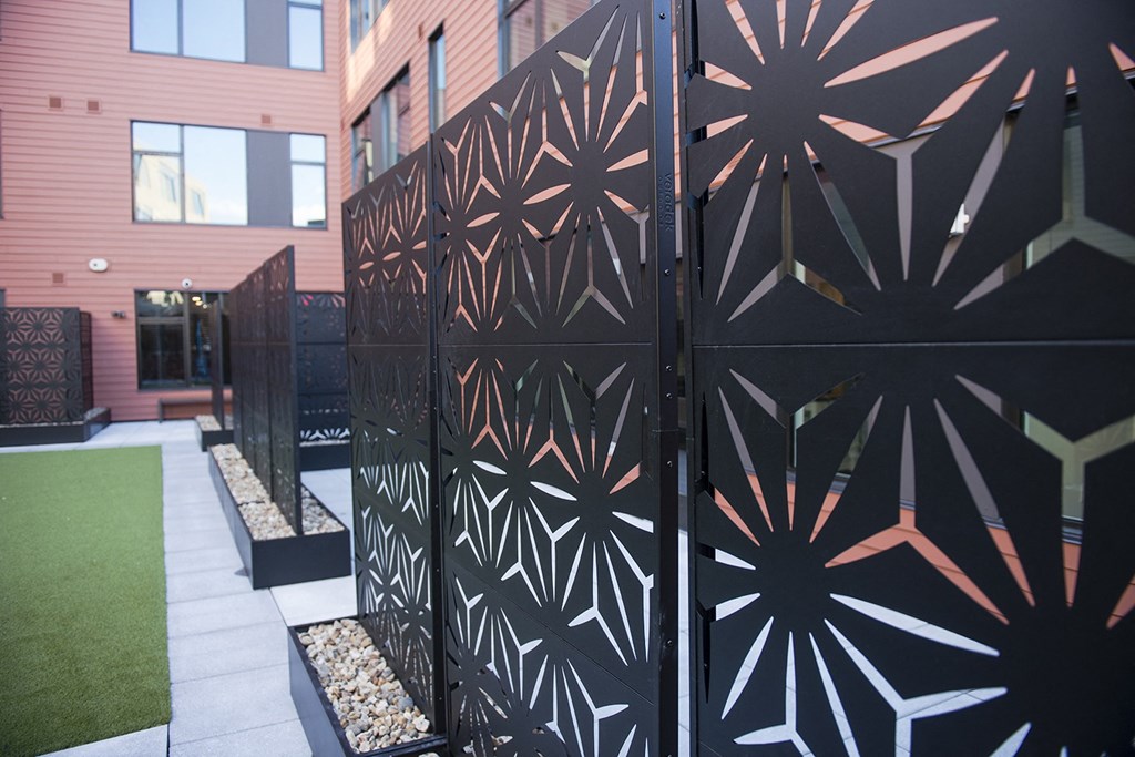 a gate in front of a building with a green lawn