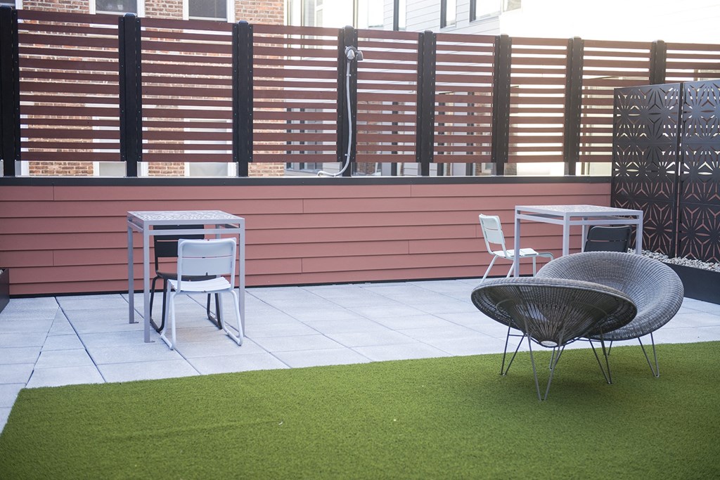 a terrace with chairs and tables and a lawn