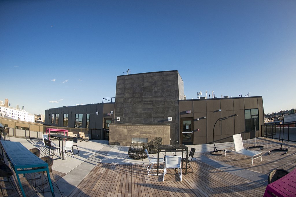 the roof terrace of the building has tables and chairs and a fireplace