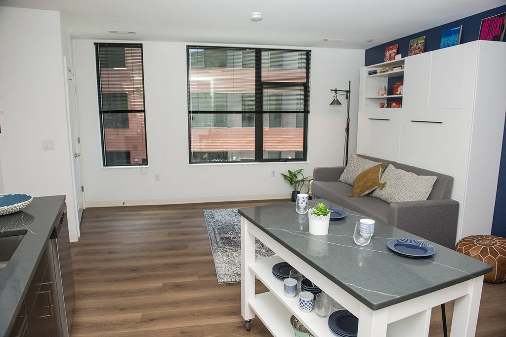 a living room with a kitchen and a large window