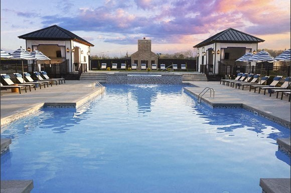 a swimming pool with chairs and umbrellas at a resort