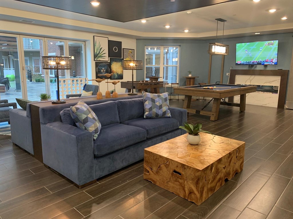a living room with a blue couch and a pool table