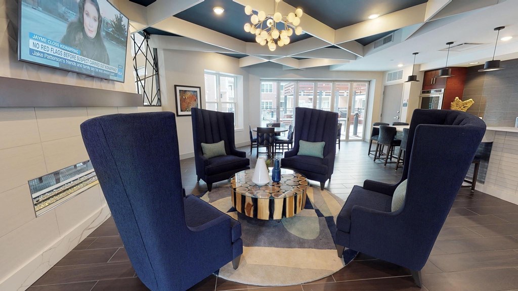 a lobby of a hotel with blue chairs and a coffee table