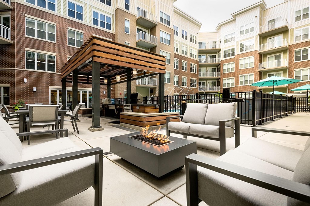 a patio with couches and a fire pit