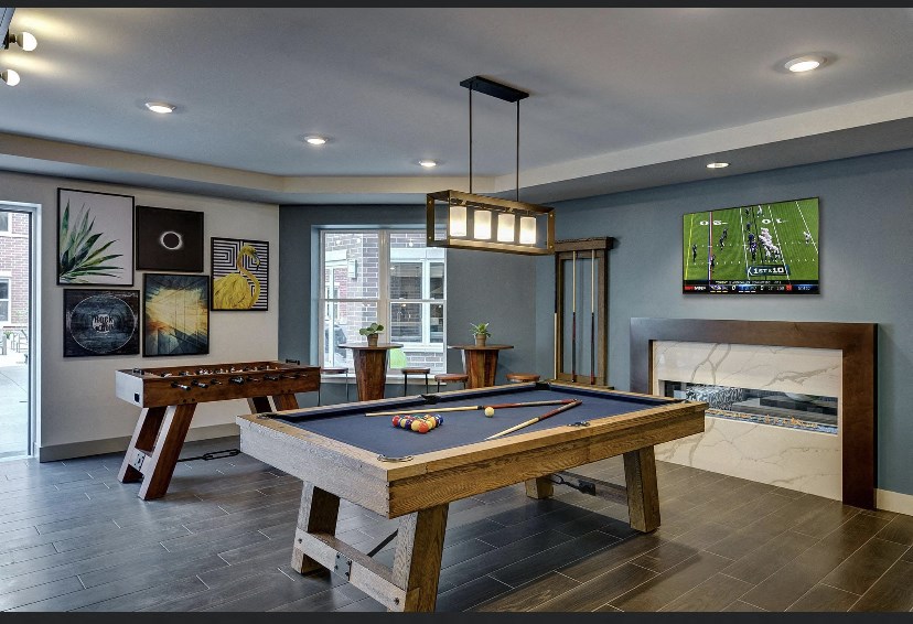 a games room with a pool table and a television