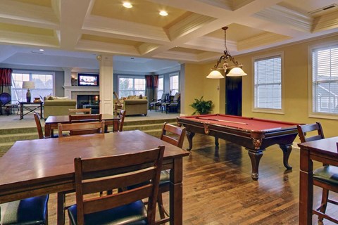 a games room with a pool table and tables