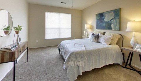 a bedroom with a bed and a desk and a window