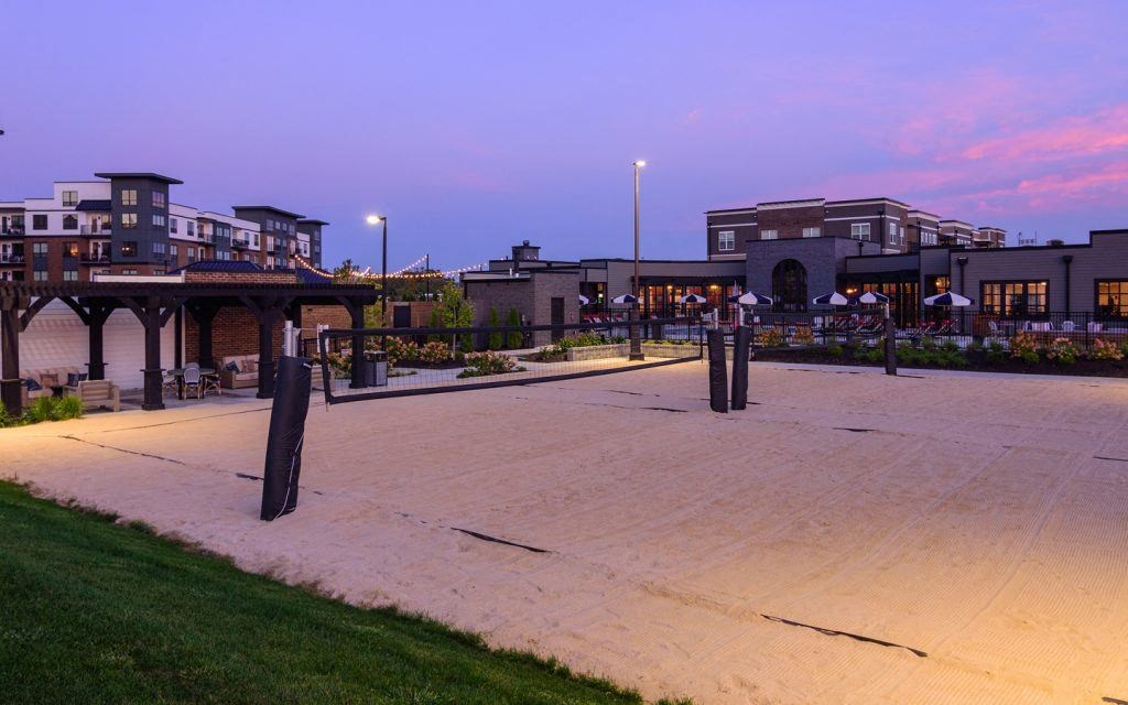 a parking lot at dusk with buildings in the background