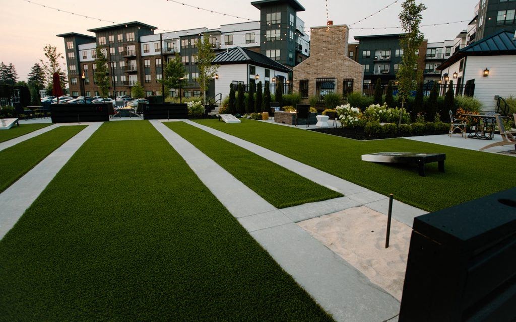 a yard with a lawn and buildings in the background