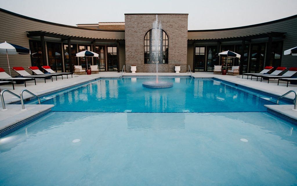 a swimming pool with a fountain in front of a building