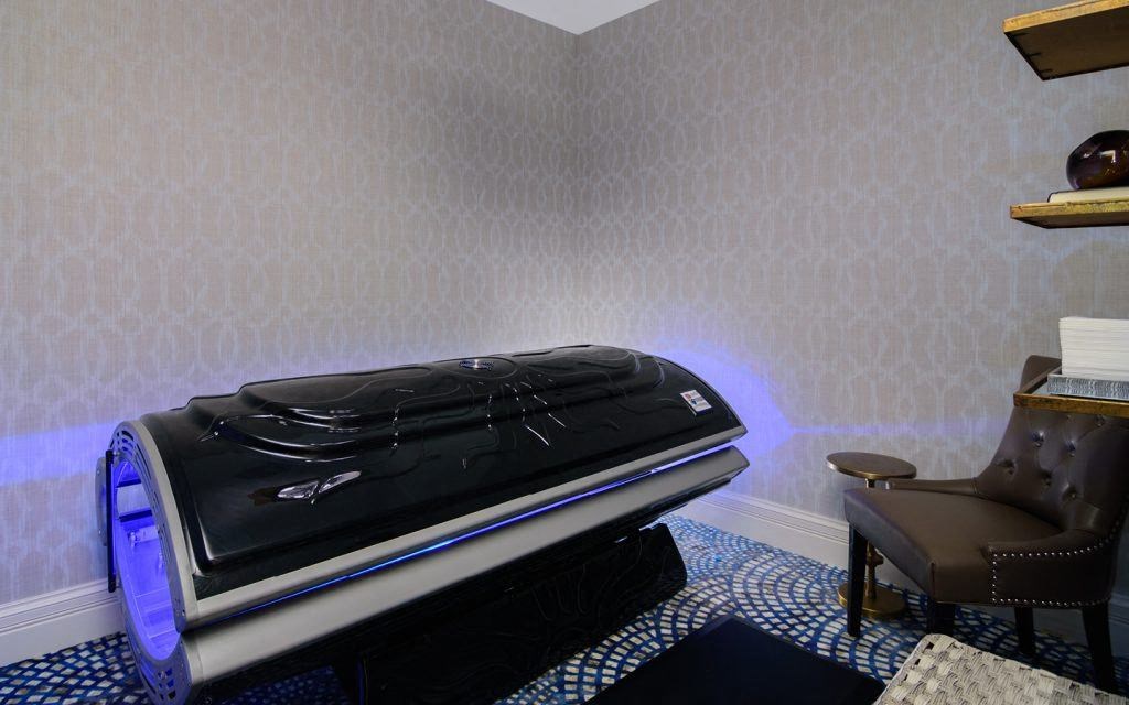 a bed in a room with a blue light on it