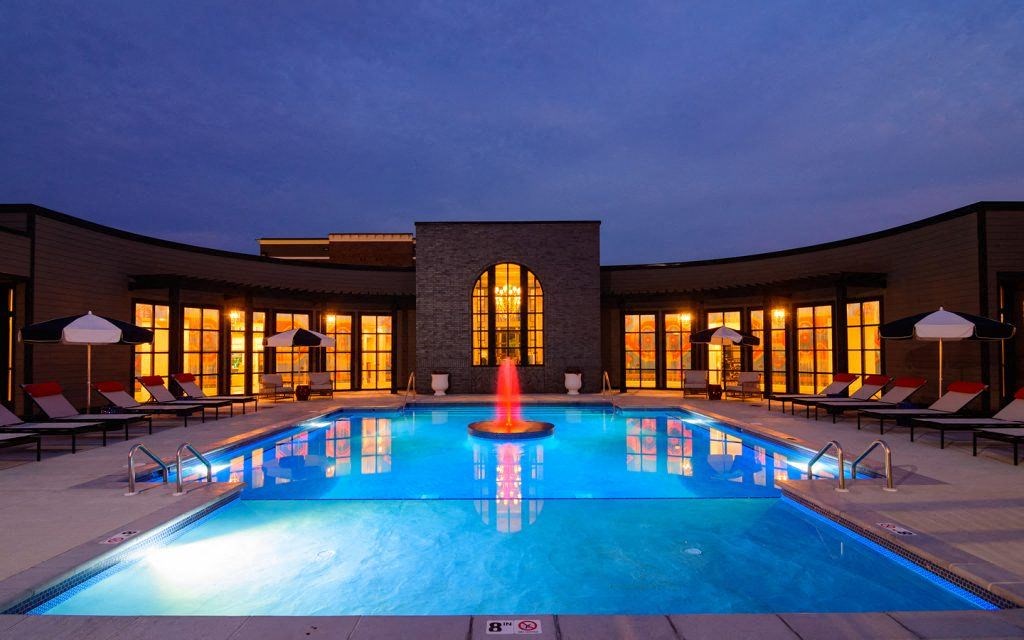 a swimming pool at night in front of a building