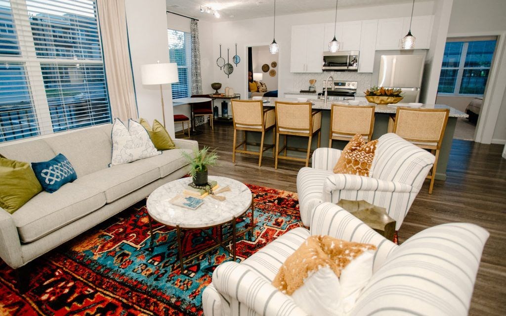 a living room with couches and chairs and a kitchen with a table