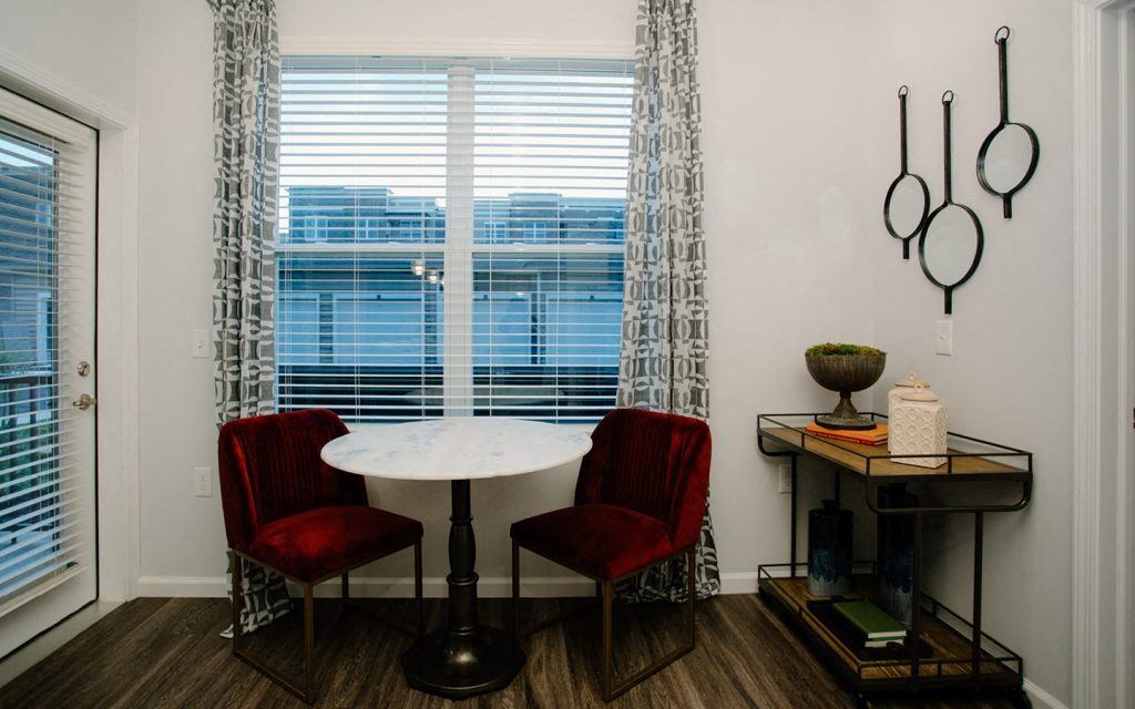 a dining room with a table and chairs and a window