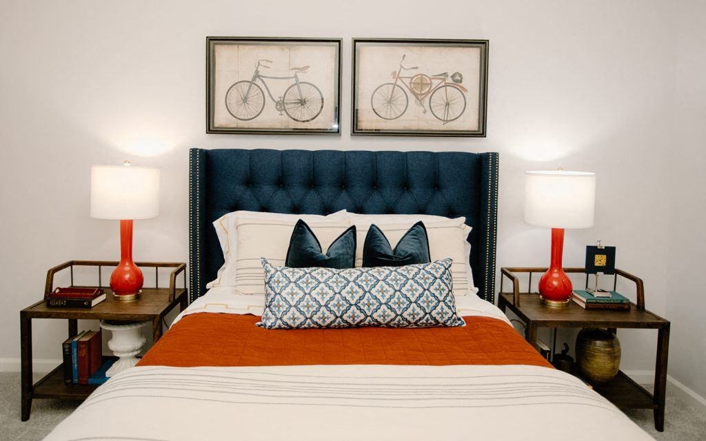 a bedroom with a bed and two pictures of bikes above it