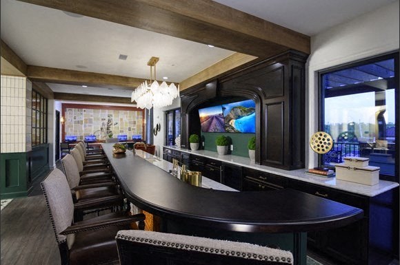 a long bar with chairs and a large window