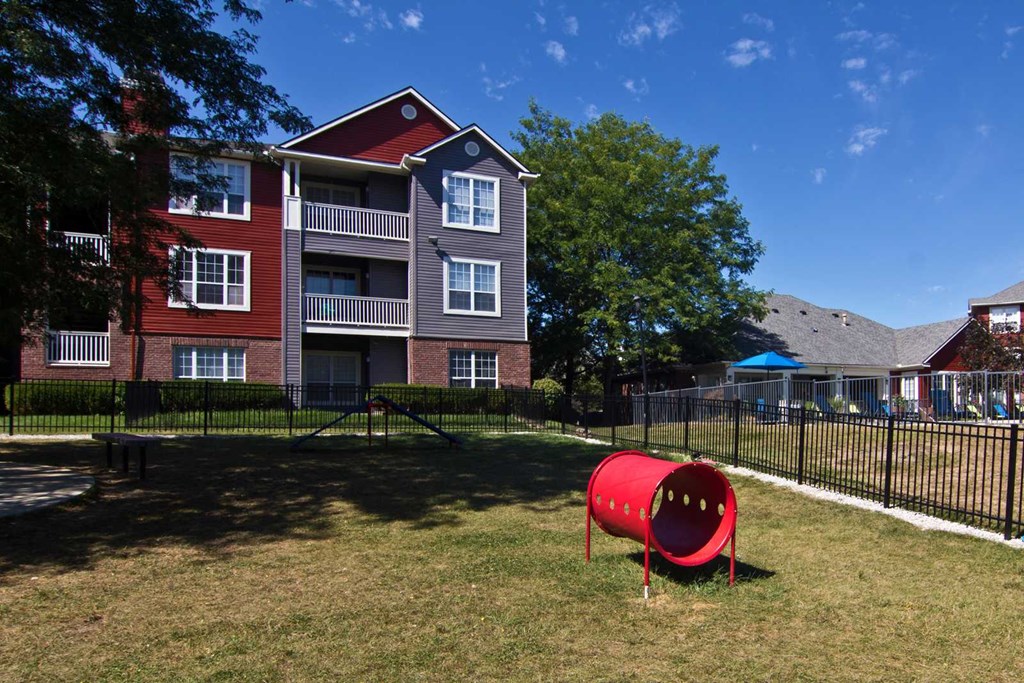 an apartment building with a large red mailbox in the yard