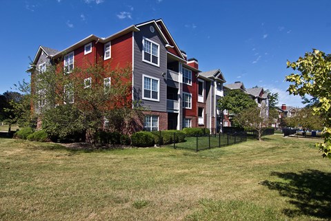 an apartment building with a yard in front of it