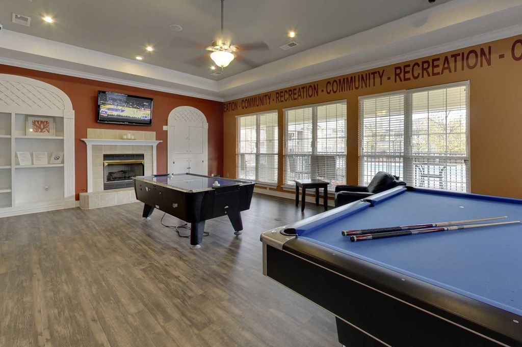 a game room with two pool tables and a tv