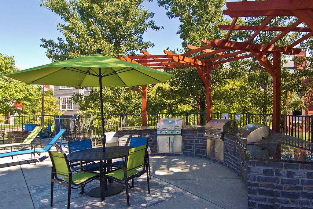 a patio with a table and chairs and a green umbrella