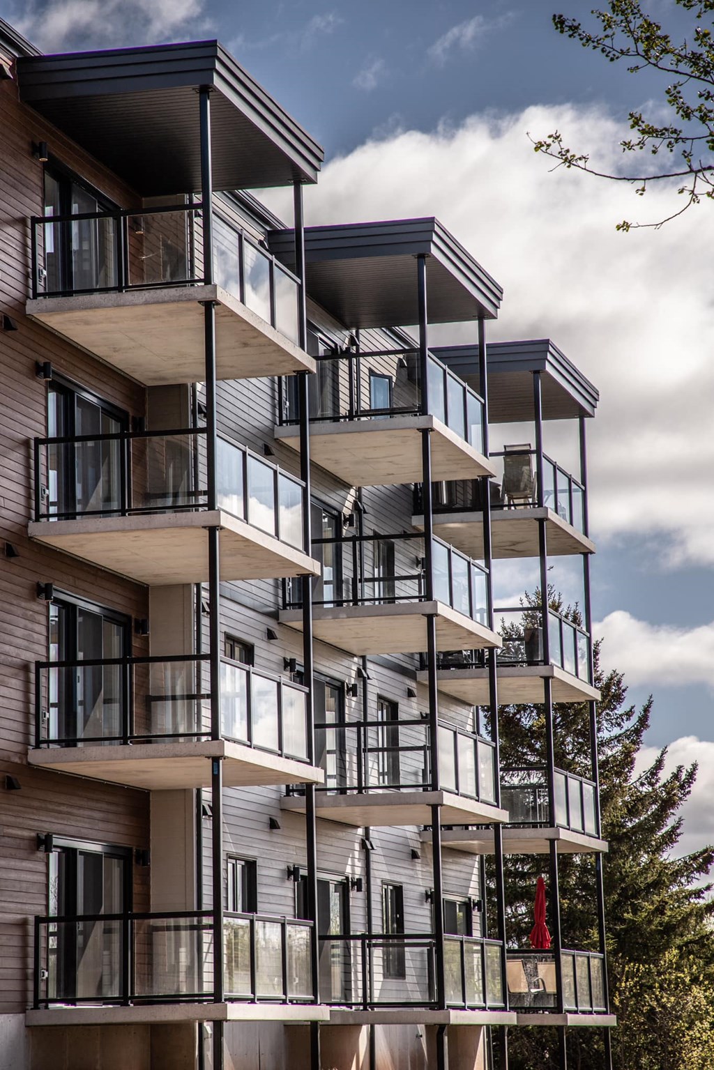 a tall apartment building with balconies and a cloudy sky