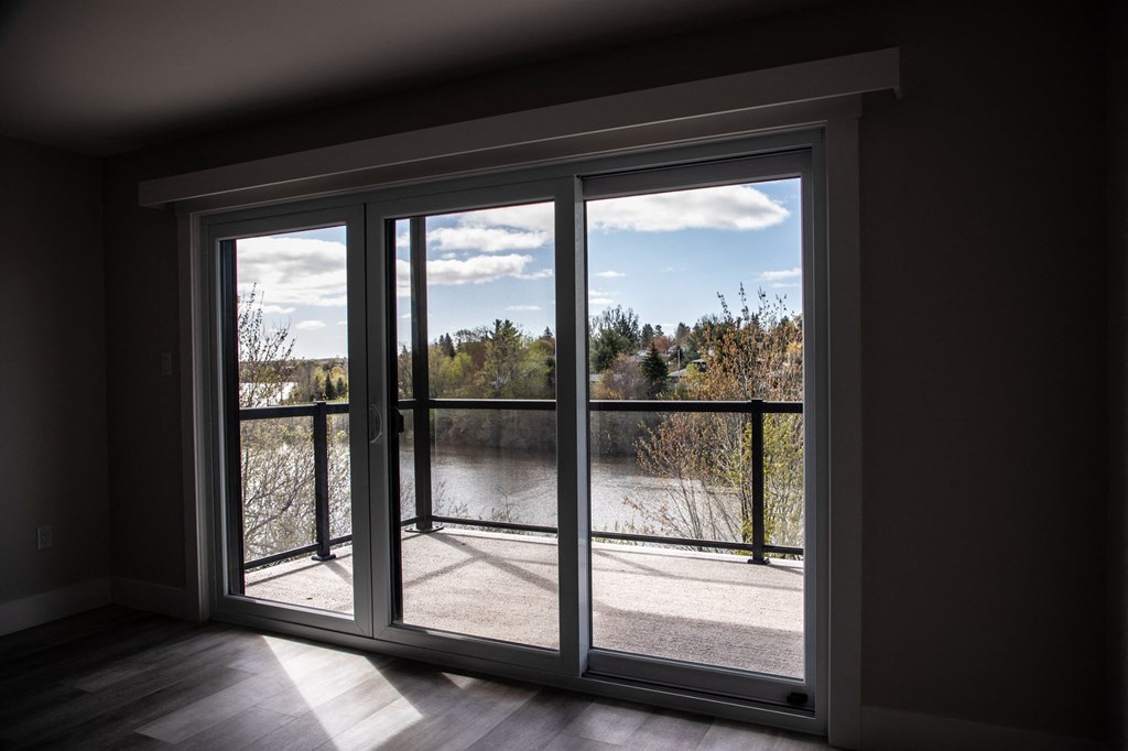 a living room with large windows and a view of a lake and trees