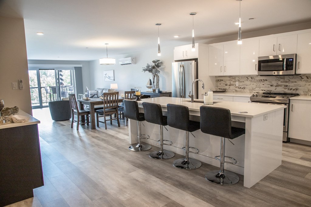 a kitchen with an island and a dining room with a table and chairs