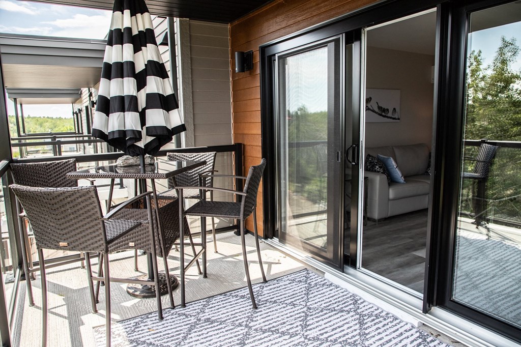 a patio with a table and chairs and sliding glass doors