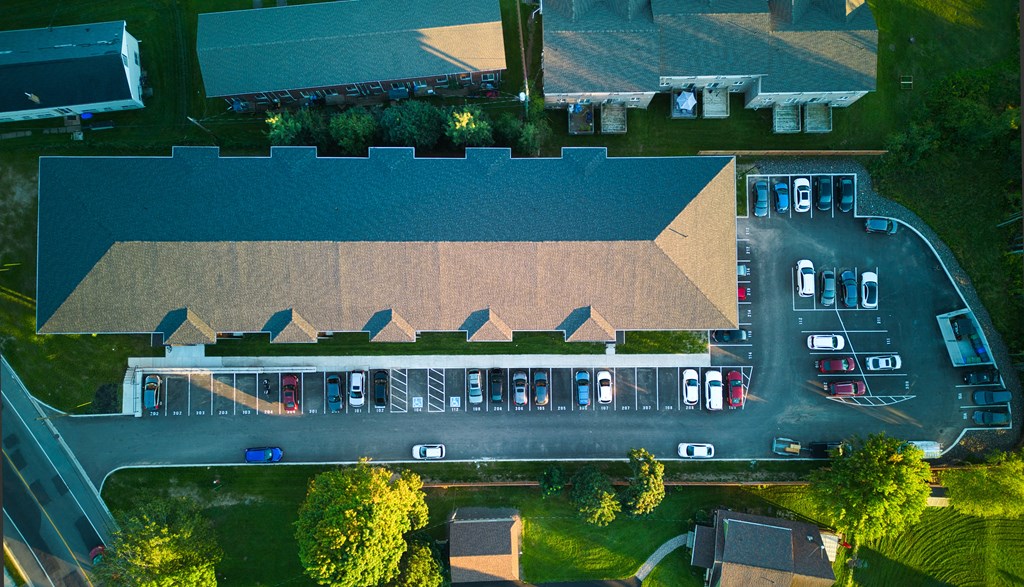 a birdseye view of a building with cars parked in a parking lot