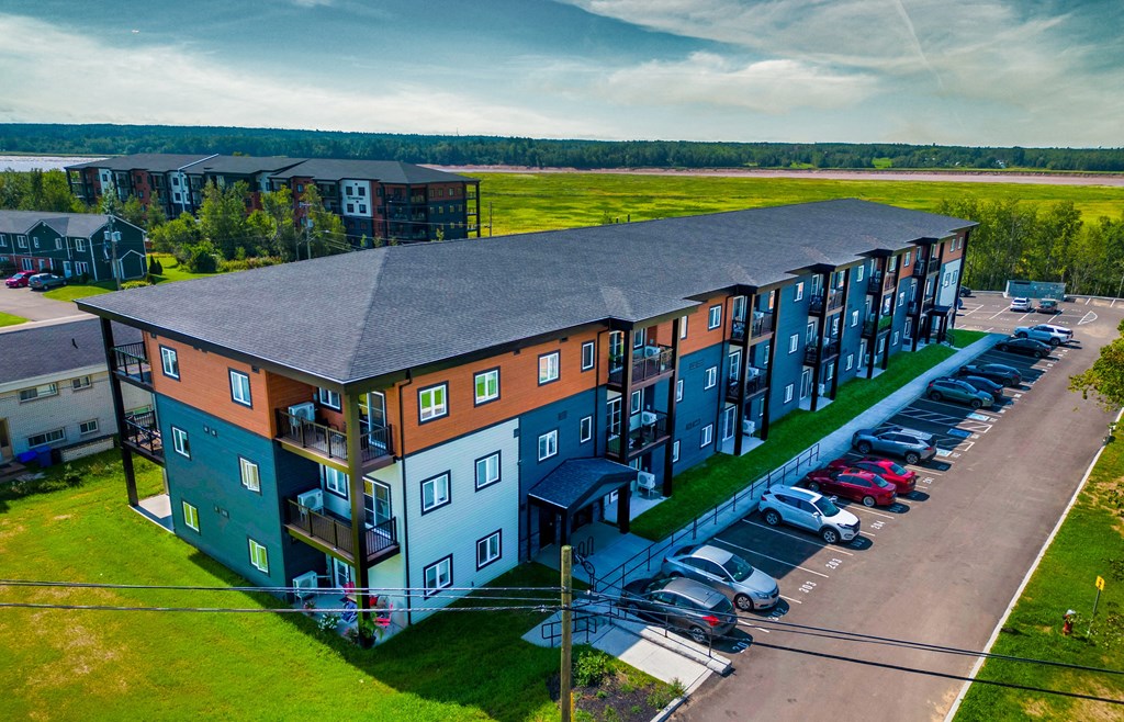an aerial view of an apartment building with a parking lot