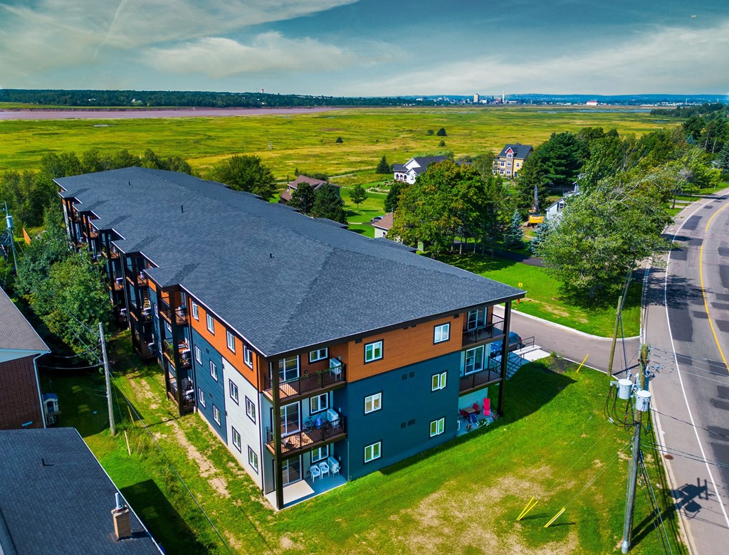 an aerial view of a building with a field in the background