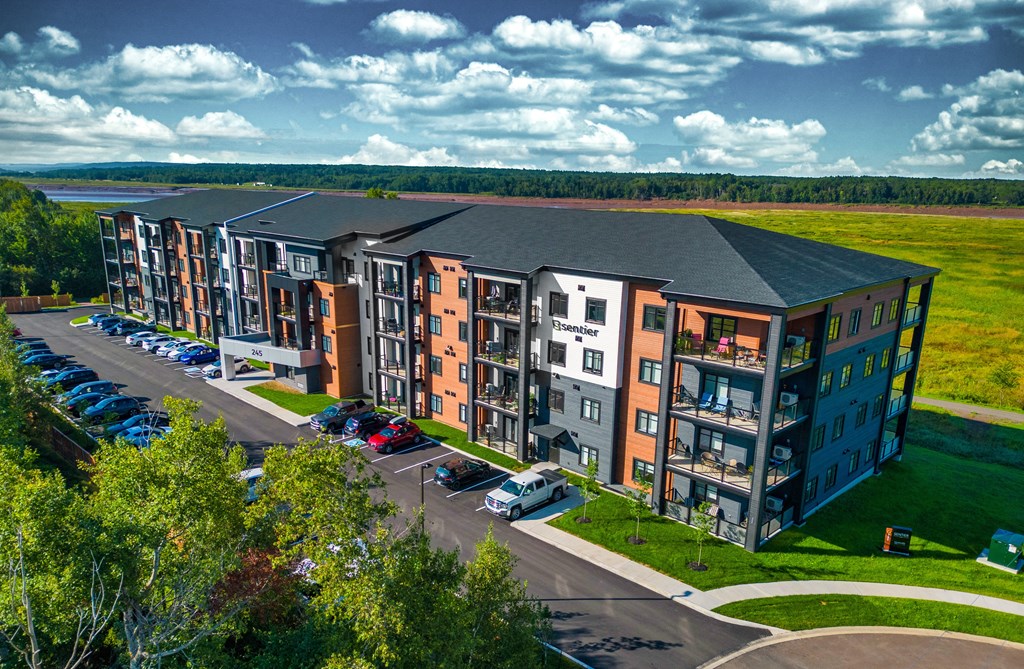 an aerial view of an apartment building with cars parked outside
