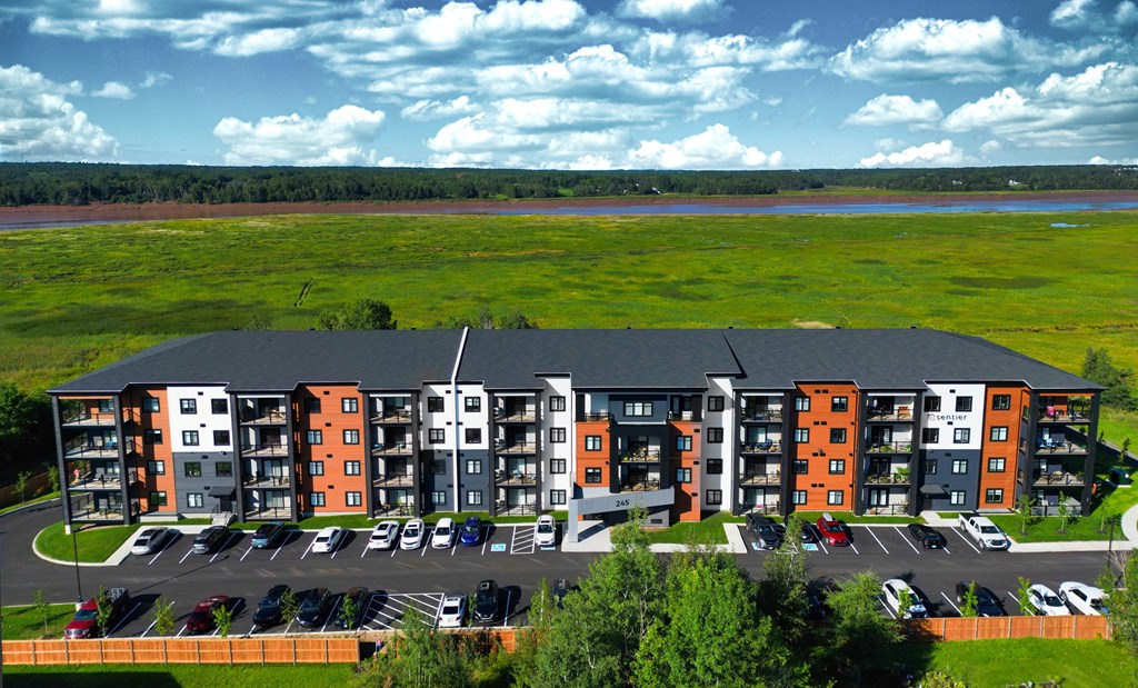 an aerial view of an apartment complex with a river in the background