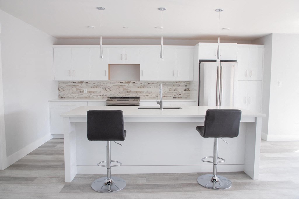 a white kitchen with two bar stools