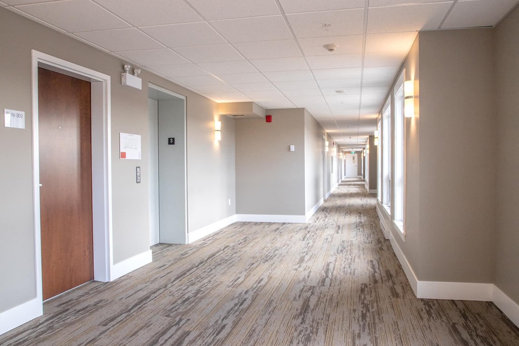 a hallway with wood floors and white walls and wooden doors