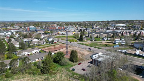 A view of a town with buildings, trees, and a clear sky.
