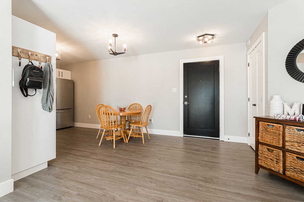 a dining room with a table and chairs and a refrigerator