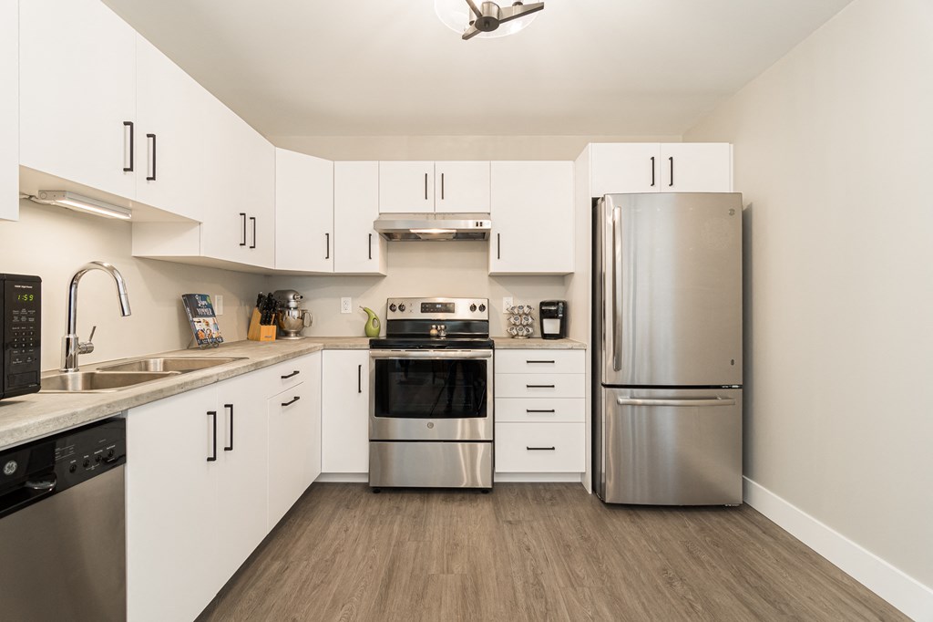 a kitchen with white cabinets and stainless steel appliances