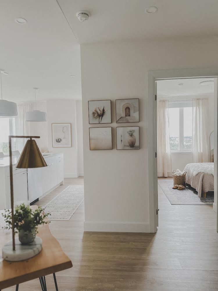 a white living room with pictures on the wall