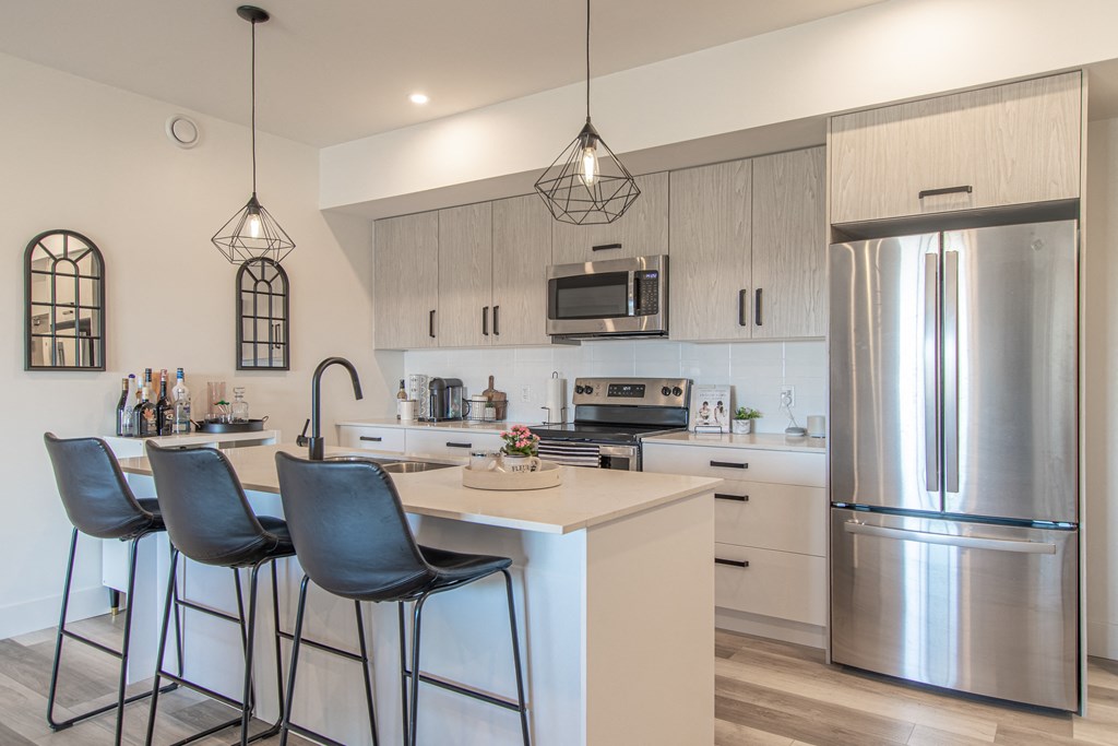 a kitchen with stainless steel appliances and a island with three stools